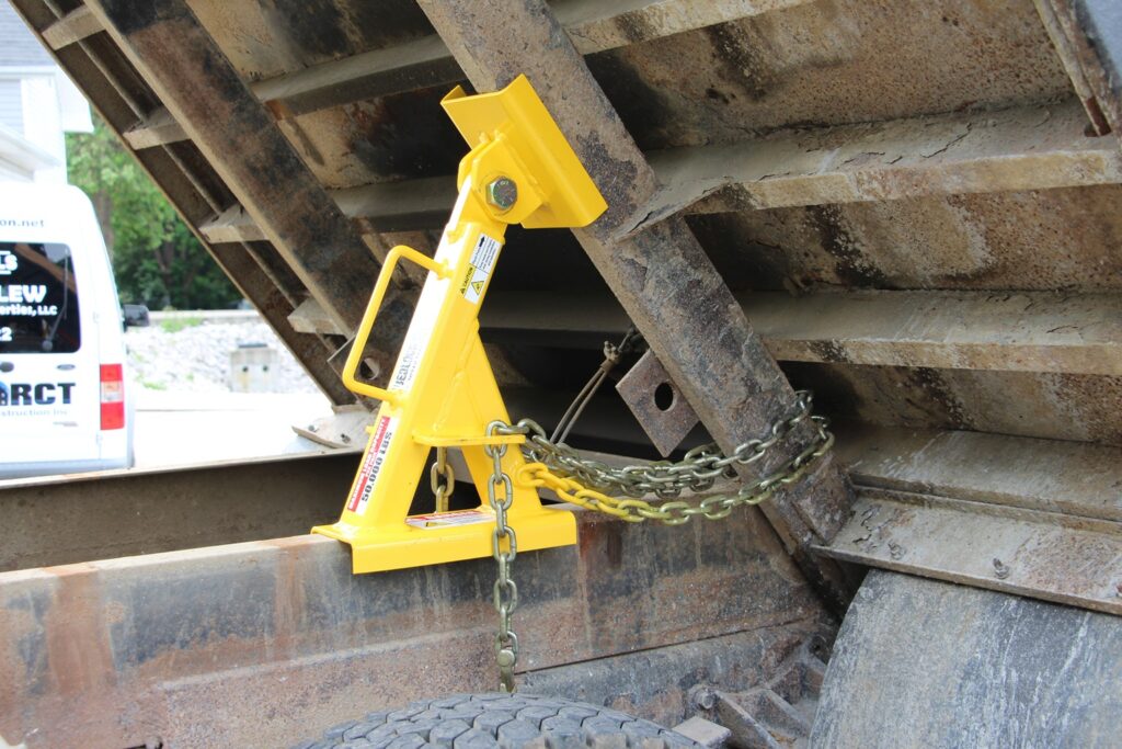 A close-up view of a properly secured bed lock on a truck's dump bed.