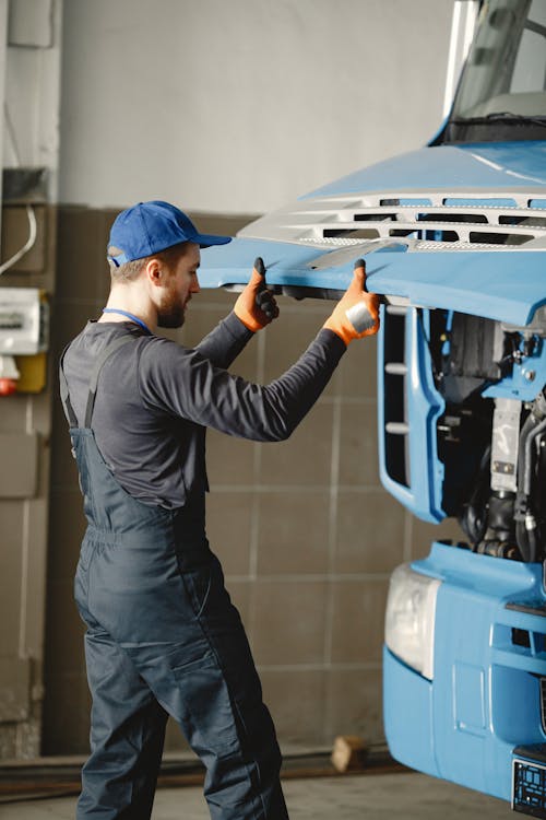 a man repairing a blue truck