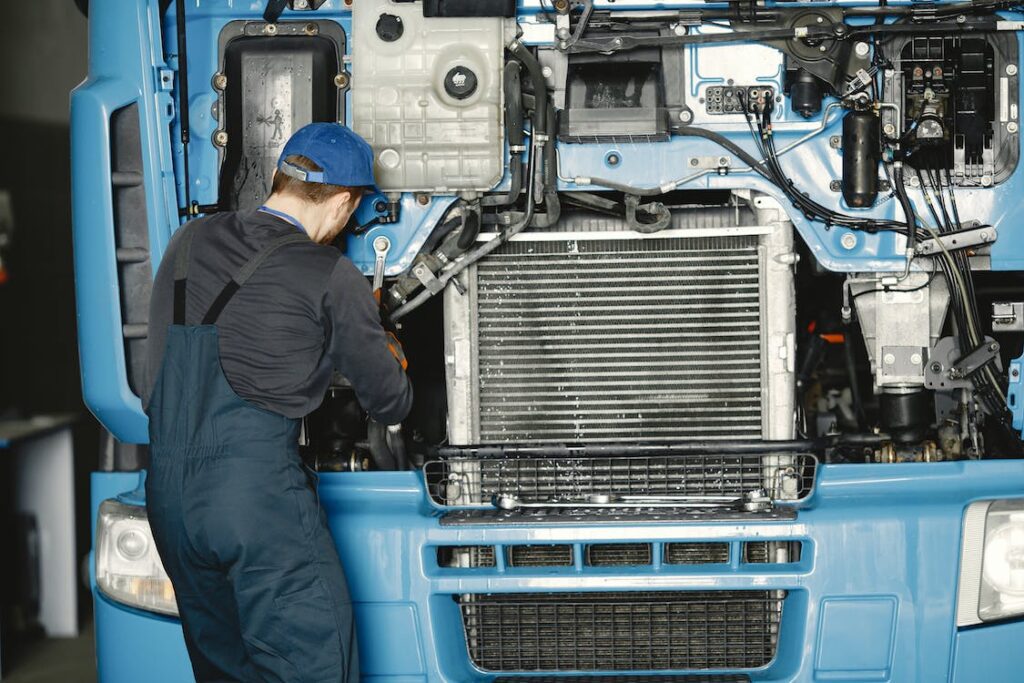 A technician is repairing a blue truck