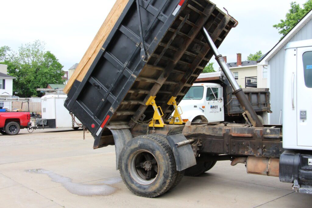 A dump truck undergoing maintenance with bed locks securely installed at a facility