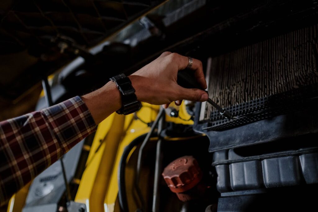 Technician working in a truck repair facility, inspecting equipment.