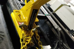 Close-up view of a BedLock safety device for dump truck maintenance.