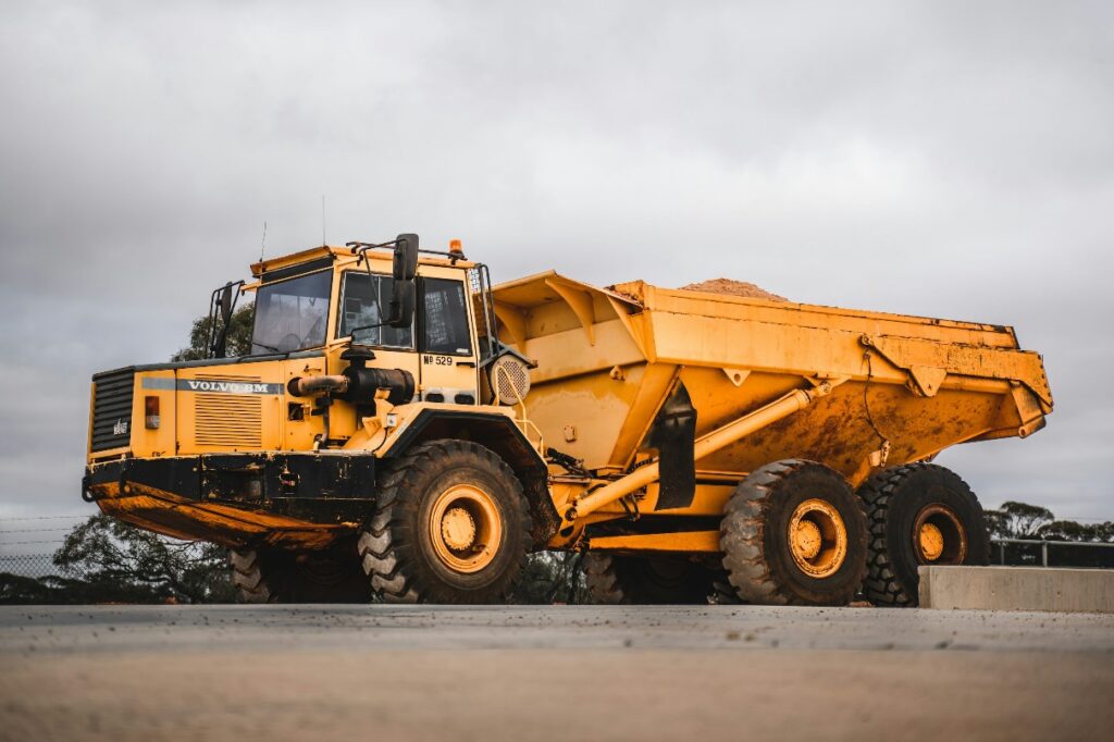 Dump truck parked on a snow-covered worksite, highlighting cold weather conditions affecting dump truck maintenance and safety operations.