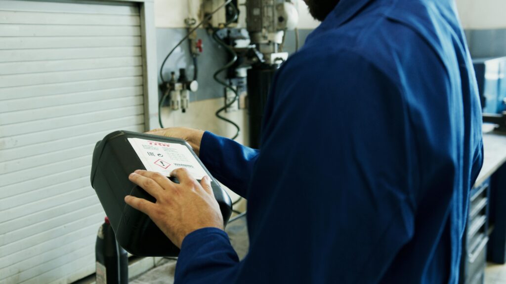 Technician reading a safety label at a truck repair facility