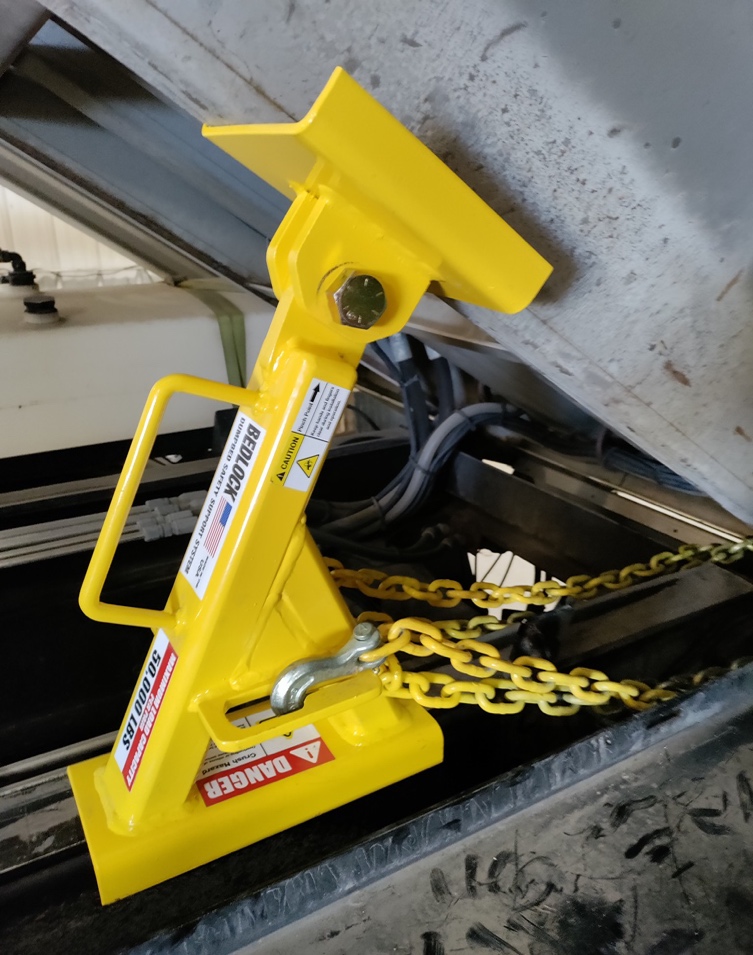 BedLock truck bed lock installed on a dump truck, providing secure support during repair work