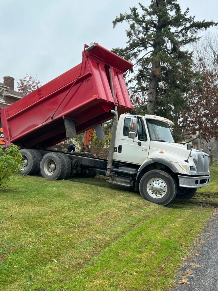 Red dump truck with raised bed during maintenance without visible safety support equipment