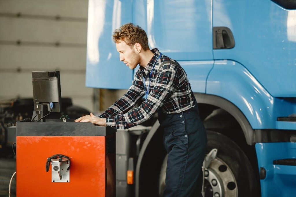 Technician using a digital monitoring system in a truck repair facility for predictive maintenance
