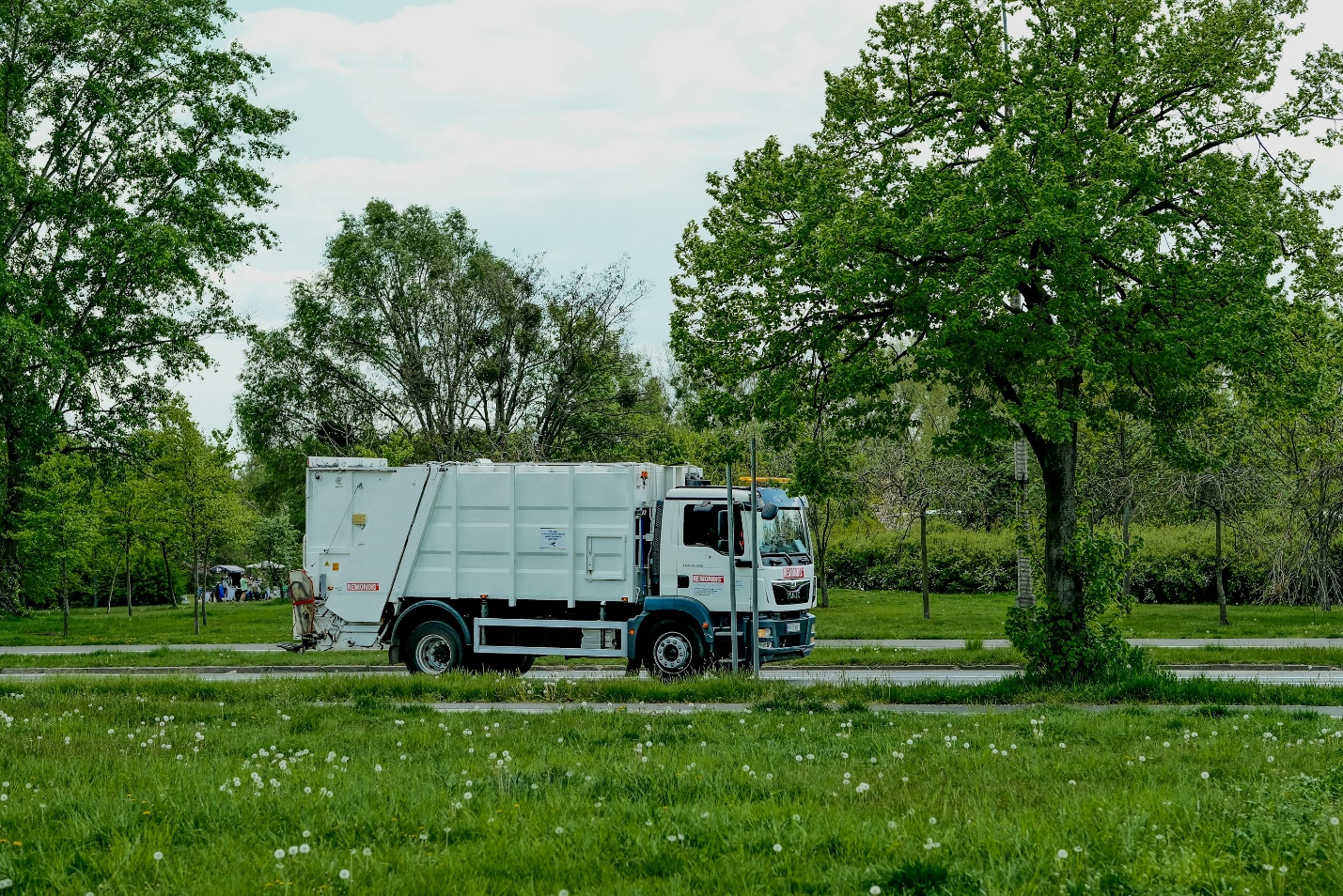 A municipal dump truck in a green area