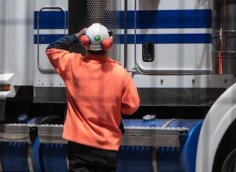 A person standing next to a freight truck