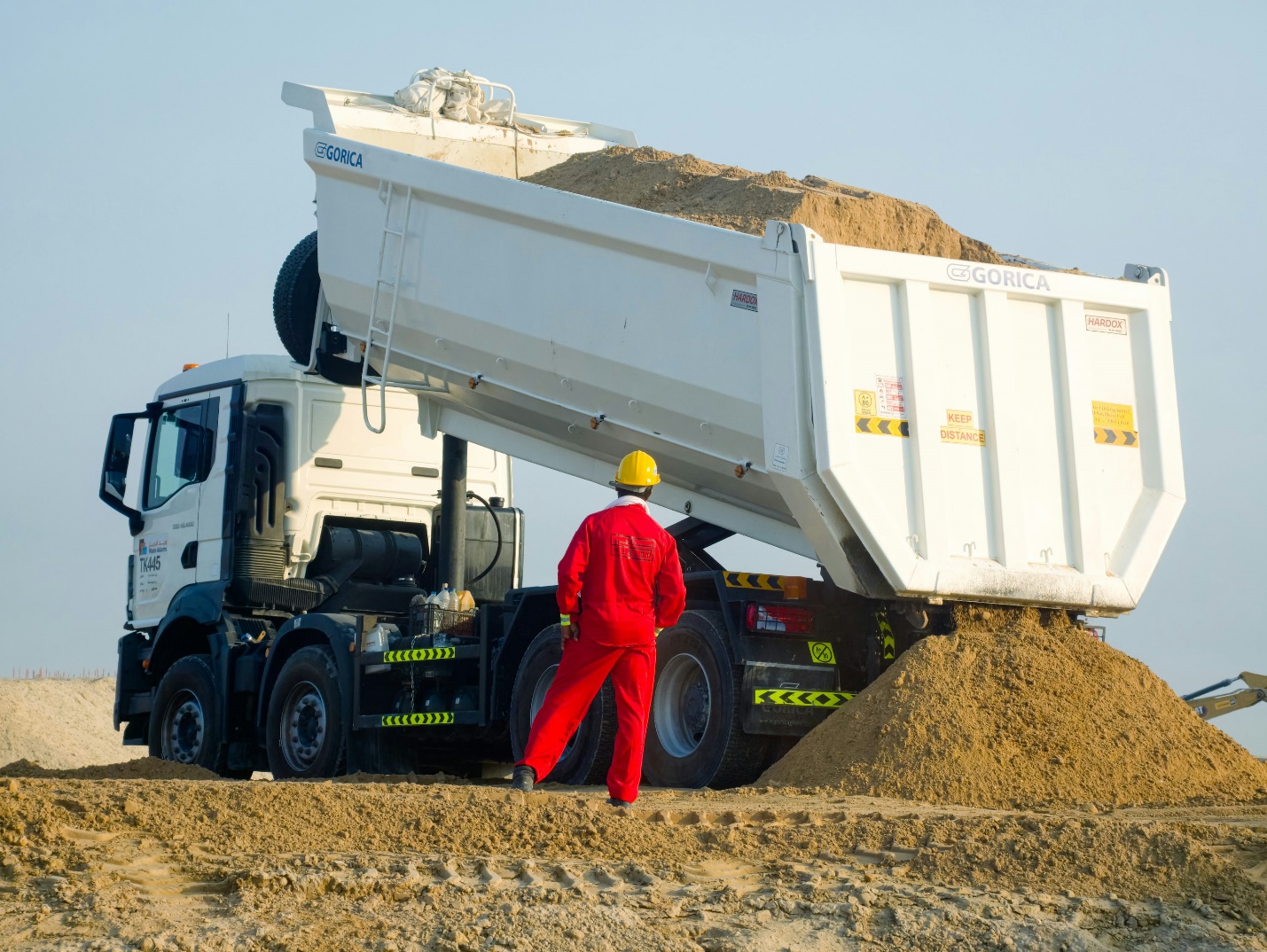 A technician checking a dump truck’s operations