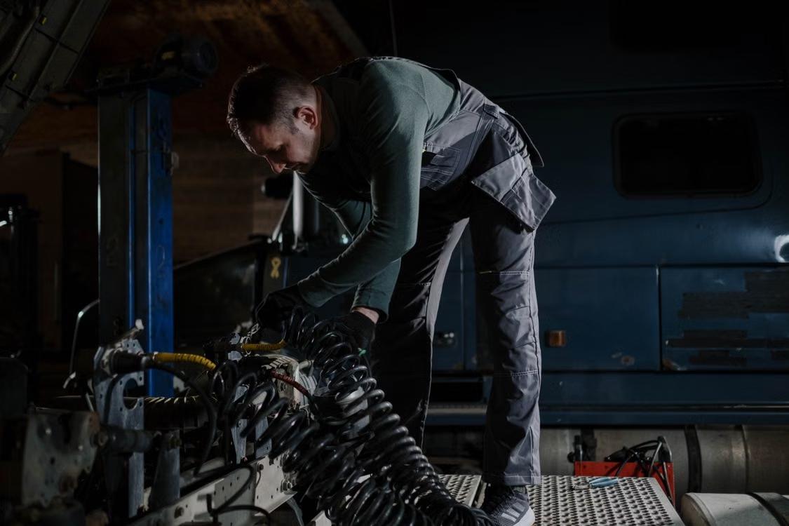 Technician repairing a truck in a service shop